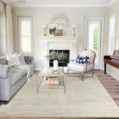 a living room filled with furniture and a piano in front of a fire place on top of a hard wood floor