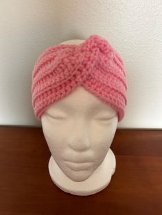 a pink knitted headband on top of a white mannequin's head