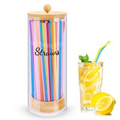 there is a glass with some straws and lemon