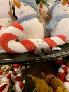 several stuffed animals are sitting on a table in front of other christmas decorations and toys