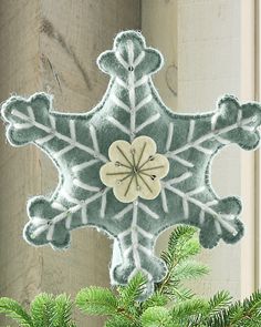 a snowflake ornament hanging from a christmas tree