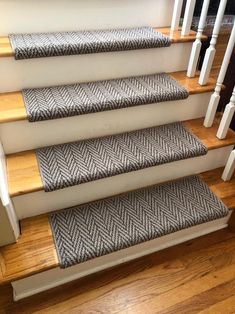 a set of stairs with carpeted treads and wooden handrails