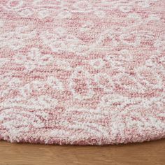 a pink and white rug on top of a wooden floor