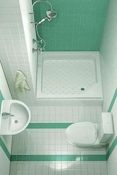 a small bathroom with green and white tiles on the floor, shower stall and toilet