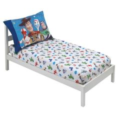 the toy story toddler bed is white and has blue pillows on top of it