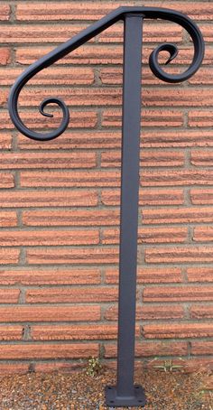 an iron handrail on the side of a brick wall