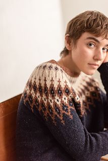 a young man sitting at a table with his hand on his chin and looking off to the side