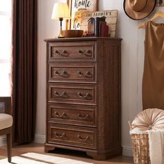 a chest of drawers sitting next to a chair in a room with a hat on top of it