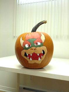 a pumpkin decorated with an image of a dragon on it's face and mouth