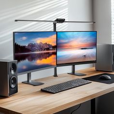 two computer monitors sitting on top of a wooden desk next to a keyboard and mouse