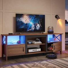 a flat screen tv sitting on top of a wooden entertainment center in a living room