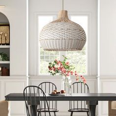 a dining room table with four chairs and a vase on the table in front of it