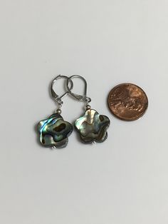 "15mm beautiful abalone shell flower shape dangle earring. Available in silver leverback or silver plated shepherd hook. Dangle 1\" long for leverback, 1.5\" for shepherd hook. You will receive the same par of earrings showing. Hand made Jewelry! Thanks for stopping by! All purchase will arrive in gifts boxes!" Adjustable Silver Shell-shaped Earrings, Silver Shell-shaped Pearl Earrings For Gifts, Nickel Free Iridescent Mother Of Pearl Earrings, Nickel-free Iridescent Mother Of Pearl Earrings, Iridescent Nickel-free Mother Of Pearl Earrings, Iridescent Mother Of Pearl Earrings, Silver Shell-shaped Earrings With Ear Wire, Silver Flower Pearl Earrings With Flower Charm, Nickel-free Silver Mother Of Pearl Earrings