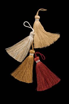 three tassels hanging from a string on a black background