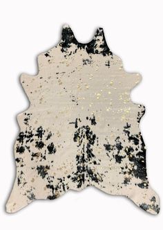 a black and white cowhide rug with gold spots on the top, in front of a white background