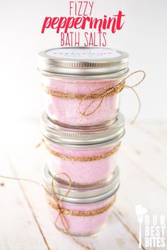 four jars filled with pink bath salts sitting on top of a wooden table next to the words fizzy peppermint bath salts