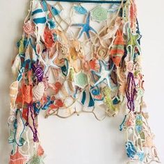 a crocheted wall hanging with starfishs and seashells on it