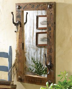 a mirror sitting on top of a wall next to a blue chair and potted plant