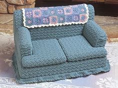 a crocheted couch sitting on top of a rug