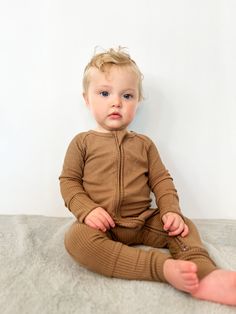 Introducing our Ribbed Zip Romper, crafted from breathable, silky smooth 95% Bamboo Viscose and 5% Spandex in custom prints. This long sleeve romper combines style, comfort, and convenience, making it a must-have for your little one's wardrobe. Key Features: Breathable & Silky Smooth: Made from 95% Bamboo Viscose and 5% Spandex, our fabric is incredibly soft and feels as luxurious as cashmere, ensuring all-day comfort. Double Zip Design: Features a double zip for easy diaper changes, providing b Long Sleeve Bodysuit For Playtime, Solid Stretch Long Sleeve Sets, Long Sleeve Bodysuit For Playtime In Fall, Fall Playtime Long Sleeve Sets, Brown Long Sleeve Sets For Spring, Long Sleeve Brown Sets For Fall, Brown Long Sleeve Sets For Fall, Casual Brown Long Sleeve Bodysuit, Stretch Ribbed Long Sleeve Sets