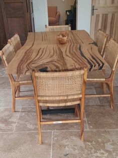 a wooden table with wicker chairs around it