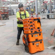 a man standing next to a stack of orange boxes