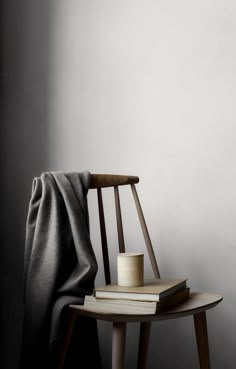 a wooden chair sitting next to a stack of books