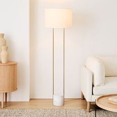 a living room with a white couch and floor lamp