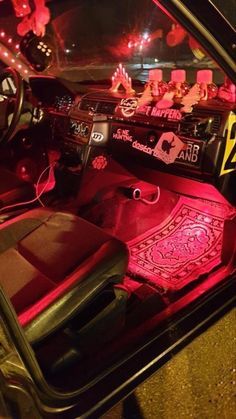 the interior of a car is lit up with red lights and decorations on it's dashboard