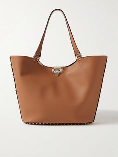 Those in the know will instantly recognize this tote as a Valentino Garavani design by the gold-tone 'Rockstud' embellishments. It's been made in Italy from textured-leather in a softly structured shape and has a flip lock at the open top. Stow everything you need, including an iPad, planner, water bottle and sunglasses case, inside. Elegant Leather Bag With Studs, Elegant Studded Leather Bags, Luxury Studded Shoulder Bag, Valentino Garavani Bag, Leather Planner, Ipad Planner, Valentino Rockstud, Brown Bags, Open Top