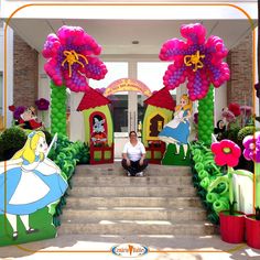 there is a man sitting on the steps in front of an entrance decorated with balloons