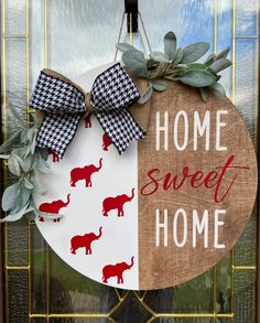 a door hanger that says home sweet home with an elephant and red elephants on it