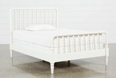 a white bed sitting on top of a cement floor