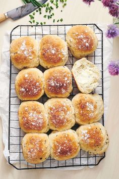 several rolls on a cooling rack with butter and sprinkles next to them