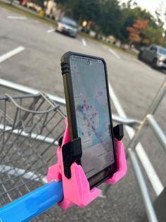 a cell phone mounted to the handle of a shopping cart