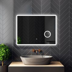 a bathroom sink with a mirror above it and a potted plant in the corner