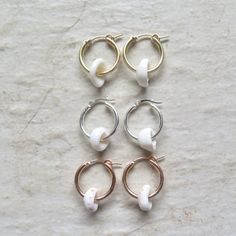 Puka Shell Hoop Earrings~ Beautiful Hawaiian puka shells adorn small tube hoops. Great gift for the beach lover! Hoops 2 X 18mm. Choose 14k gold fill, rose gold fill or sterling silver from the drop down menu. Models wearing similar designs. Shop~ http://www.etsy.com/shop/HanaMauiCreations?ref=pr_shop_more International buyers please read our shipping policies before ordering~ POLICIES~ https://www.etsy.com/shop/HanaMauiCreations/policy?ref=shopinfo_policies_leftnav Adjustable Small Hoop Earrings For Beach, Adjustable Small Hoop Jewelry For Beach, Nickel Free Small Hoop White Jewelry, Dainty Handmade White Huggie Earrings, White Hoop Earrings Summer Gift, White Hoop Earrings As Summer Gift, Handmade Dainty White Huggie Earrings, White Small Hoop Earrings For Beach, White Hoop Earrings For Summer Gift