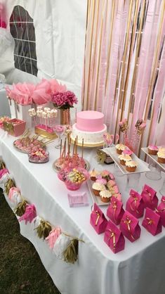 a table topped with pink and gold desserts