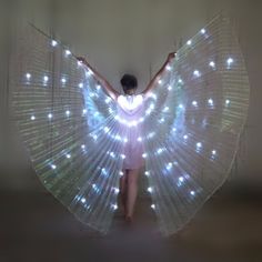 a woman is dressed up as an angel with lights on her body and wings spread out