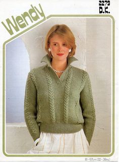 a woman wearing a green sweater and white skirt