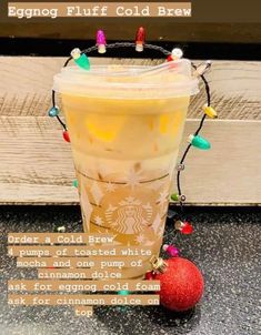 an iced drink with christmas lights around it and a red ornament on the side