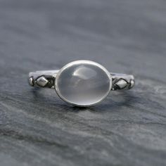 Luminous oval moonstone set in solid sterling silver on a solid sterling silver ring band.Cat eye moonstone gemstone is approximately 3/8" x 1/4" Modern moonstone is a birthstone for June. It's associated with the zodiac sign of Gemini. Moonstone is thought to bring good luck and fortune.This ring will be made to order in your size. Please select your size from the drop down menu.For more rings:https://www.etsy.com/shop/KiraFerrer?ref=hdr_shop_menu&section_id=5254786To see my entire collecti Silver Celestial Jewelry With Oval Cabochon, Silver Oval Moon Phase Ring, Celestial Silver Opal Ring, Silver Mystical Moonstone Ring, Silver Oval Ring With Moon Phase, Sterling Silver Round Moonstone Ring With Moon Phase, Silver Oval Rings With Moon Phase, White Moonstone Opal Ring In Oval Cabochon Shape, Mystical Oval Cabochon Rings