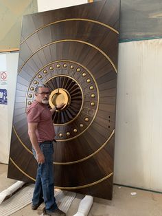 a man standing in front of a large wooden object