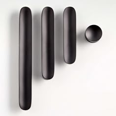 three black handles and two spoons on a white surface