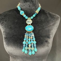 This Is A 16” Statement Piece Chico’s Necklace. It Has An Eye-Catching 6” Additional Extension At The Neckline. It Also Has A 5” Chain Extension At The Nape. The Primary Color Is A Rich Turquoise, But Also Has A Blue Swirl Design Mother-Of-Pearl Disk Holding The Primary Cabochon. The Rear Beading Is A Double Strand Of Natural Cut Stones In A Grayish-Turquoise Design. Elegant Large Beads Turquoise Necklace, Elegant Turquoise Necklace With Large Blue Beads, Elegant Blue Turquoise Necklace With Large Beads, Blue Large Beads Necklace, Elegant Blue Turquoise Necklace With Faceted Beads, Elegant Blue Turquoise Necklace With Colorful Beads, Blue Beaded Necklaces With Natural Stones And Dangle Shape, Blue Beaded Dangle Necklaces With Natural Stones, Blue Beaded Necklaces With Natural Stones