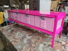 a pink table with drawers on top of it