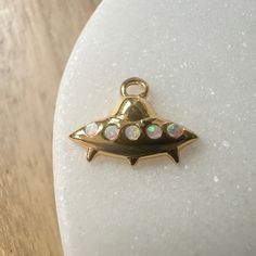 Whether you're a 👽 believer or not, this mini mothership charm is too cute to pass up. Wear it on it's own or on a jumble alongside your favorite charms on a necklace, bracelet, or strung upon hoops. Charm measures 6mm x 12mm. Simulated opal. Comes with a removable oval jump ring. Our materials make for an amazing, high quality, seamless, jewelry piece with longevity. Our rings are plated with 18k gold, 18k rose gold, or sterling silver and finished with a protective coating. A little secret we Dainty Nickel-free Charms For Gifts, Removable Dangle Charms For Friendship, Small Dangling Charms For Gifts, Nickel Free Pendant Charms For Gifts, Nickel-free Pendant Charms For Gifts, Rose Gold Sterling Silver Jewelry For Friendship, Symbolic Nickel-free Dangle Charms, Small Charm Necklaces For Gifts, Small Charms Jewelry For Gifts