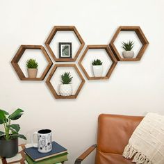 three hexagonal wooden shelves on the wall above a leather chair and coffee table