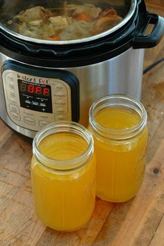 two jars filled with liquid sitting next to an instant pot