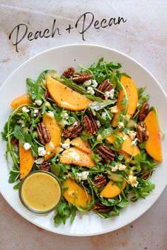 a salad with pecans and oranges on top is served in a white bowl